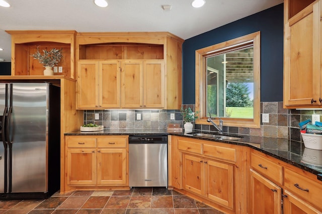 kitchen featuring tasteful backsplash, sink, dark stone counters, and appliances with stainless steel finishes