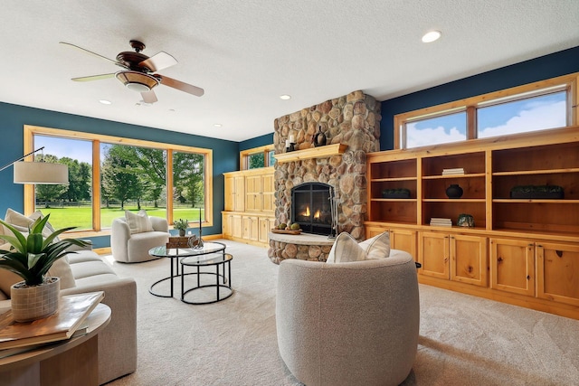 living room with a healthy amount of sunlight, a fireplace, light carpet, and a textured ceiling