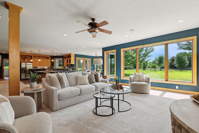 carpeted living room with ceiling fan