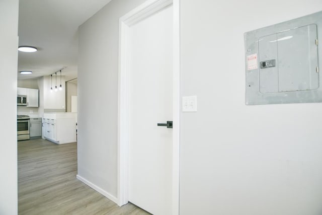 hallway with light hardwood / wood-style flooring and electric panel