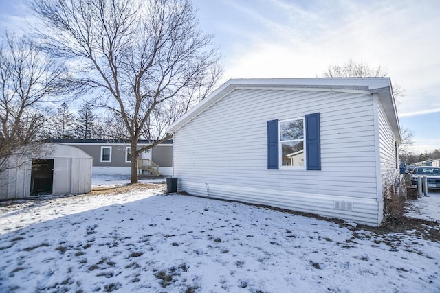 view of snowy exterior with a storage shed