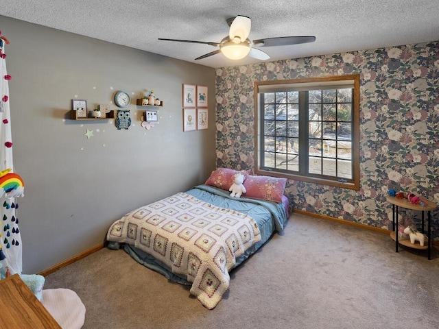 bedroom with ceiling fan, carpet floors, and a textured ceiling