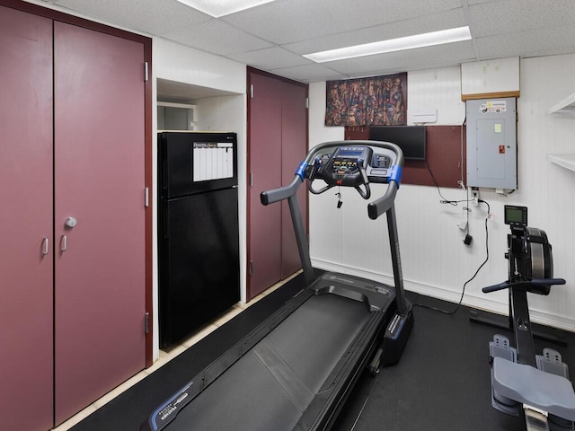 workout area with a drop ceiling and electric panel