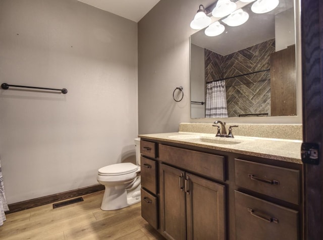 bathroom featuring visible vents, toilet, wood finished floors, curtained shower, and vanity