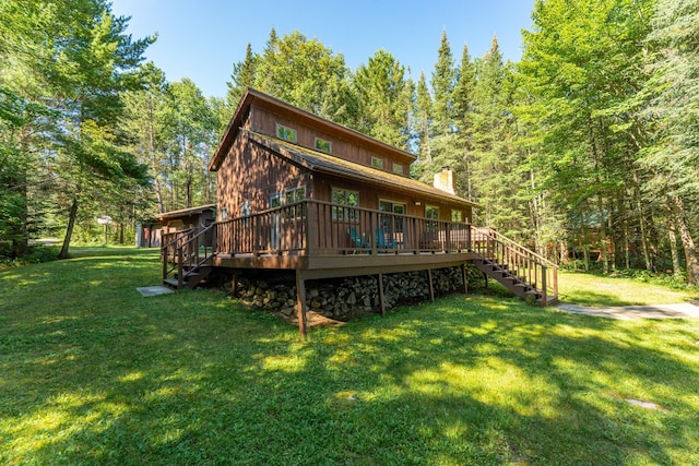 back of house with a wooden deck and a lawn