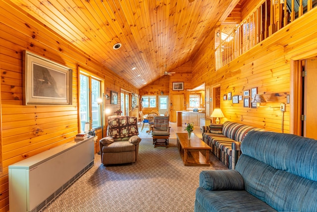 carpeted living room featuring wood ceiling, radiator heating unit, high vaulted ceiling, and wood walls