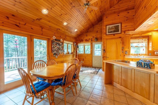 dining space featuring wooden walls, sink, light tile patterned floors, ceiling fan, and wooden ceiling