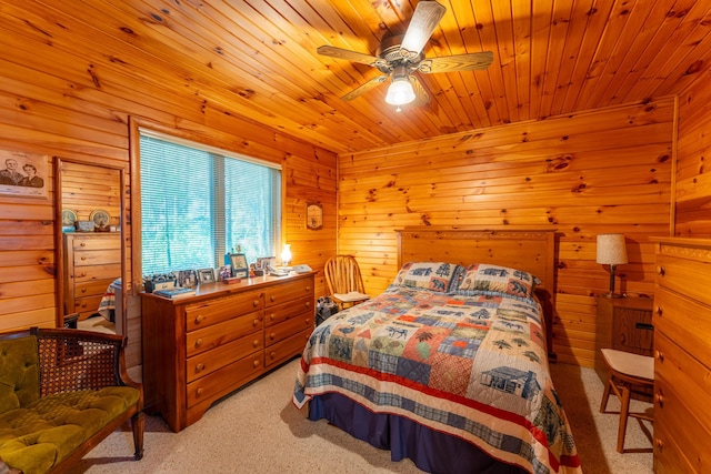 bedroom featuring ceiling fan, wooden walls, light carpet, and wooden ceiling