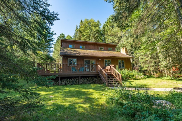 rear view of property featuring a lawn and a deck