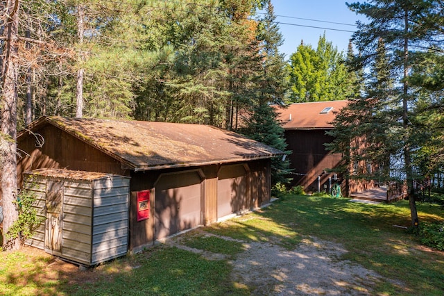 view of outdoor structure with a garage and a lawn