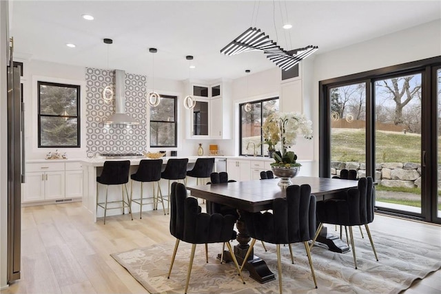 dining area with sink and light hardwood / wood-style flooring