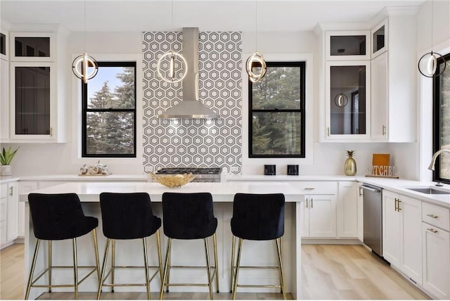 kitchen with white cabinetry, a kitchen breakfast bar, light hardwood / wood-style floors, and pendant lighting