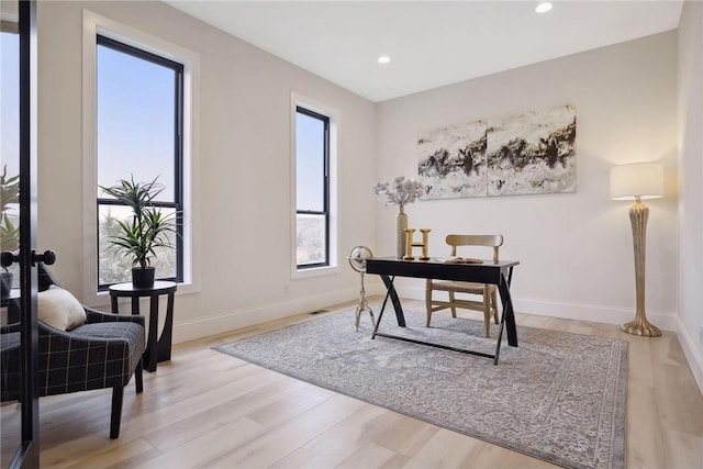 home office with light hardwood / wood-style floors