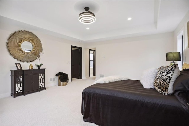 carpeted bedroom with a raised ceiling