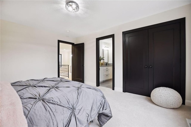 bedroom featuring ensuite bathroom and carpet floors