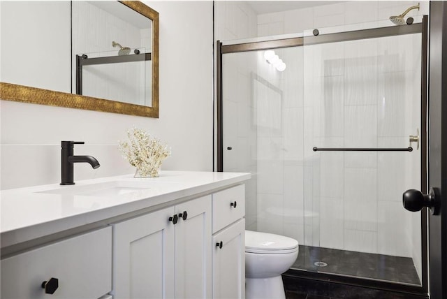 bathroom with vanity, a shower with door, and toilet