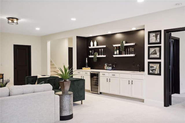 bar featuring light colored carpet, beverage cooler, sink, and white cabinets