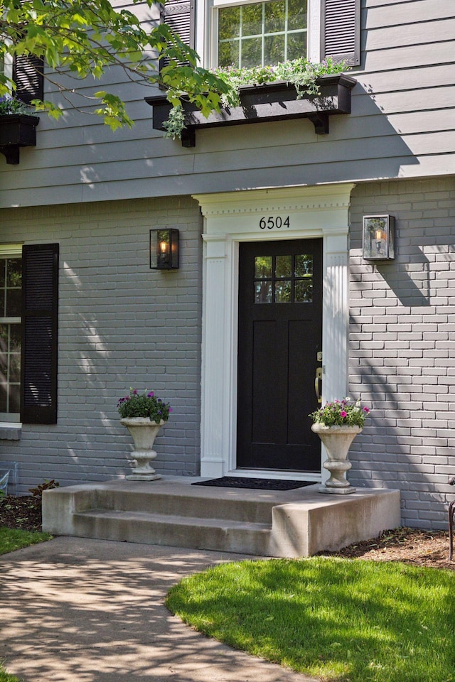 property entrance featuring brick siding