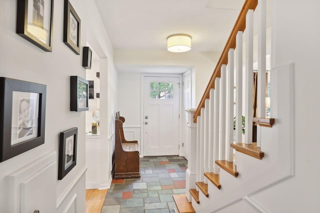 foyer entrance featuring stairway and stone tile flooring