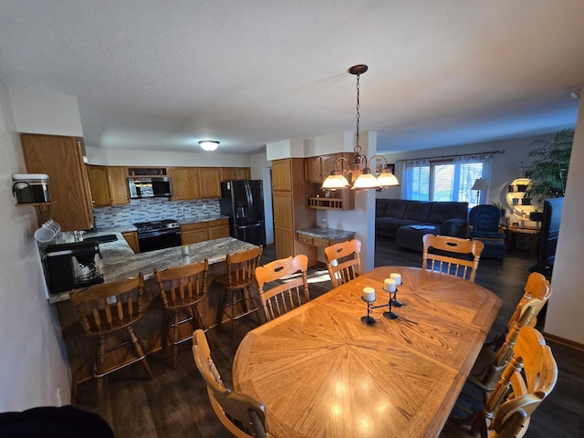 dining space featuring dark hardwood / wood-style floors, sink, and a chandelier