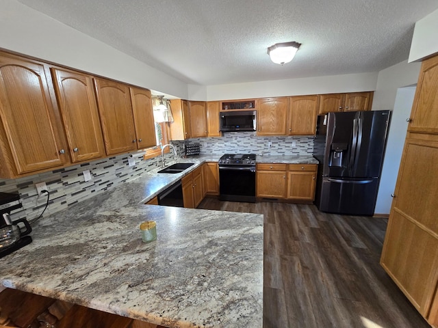 kitchen featuring gas range, sink, fridge with ice dispenser, and kitchen peninsula