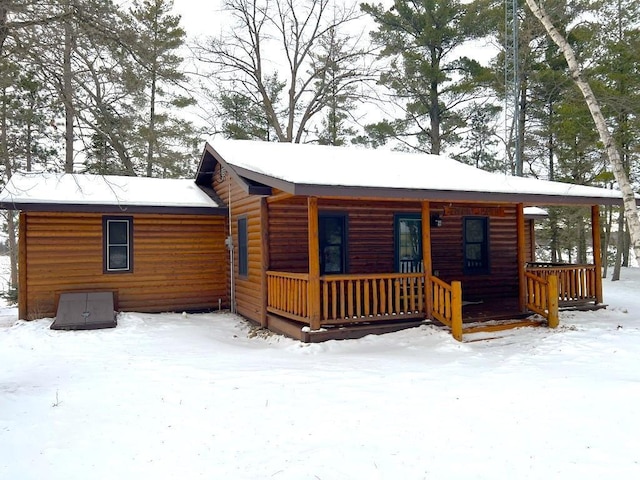 log home featuring covered porch