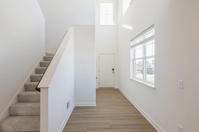 stairway featuring a high ceiling and wood-type flooring