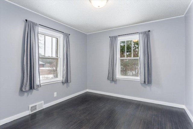 empty room with ornamental molding, dark wood-type flooring, and a textured ceiling