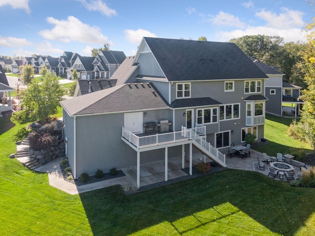 back of house featuring an outdoor fire pit, a patio, and a lawn