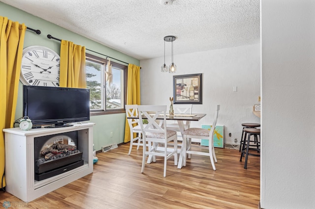 dining room featuring hardwood / wood-style floors and a textured ceiling