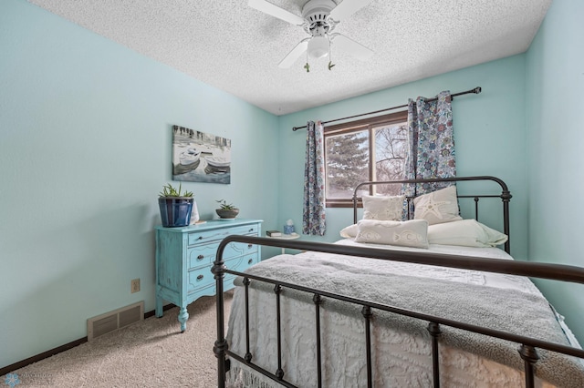 carpeted bedroom featuring a textured ceiling and ceiling fan