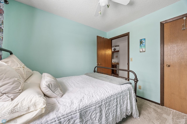 carpeted bedroom featuring a textured ceiling and ceiling fan