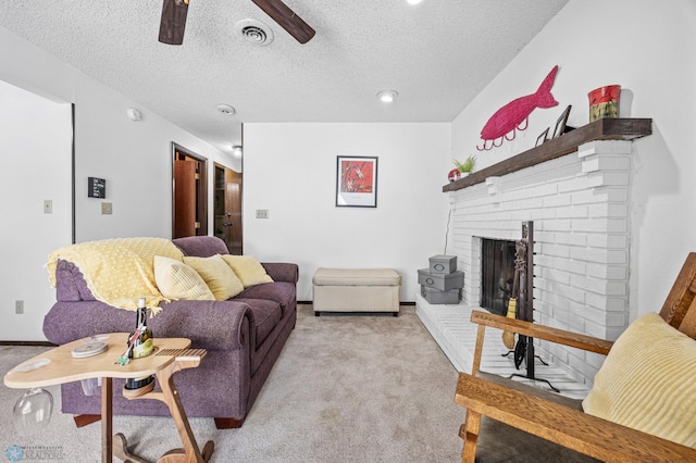 living room with light carpet, ceiling fan, a fireplace, and a textured ceiling