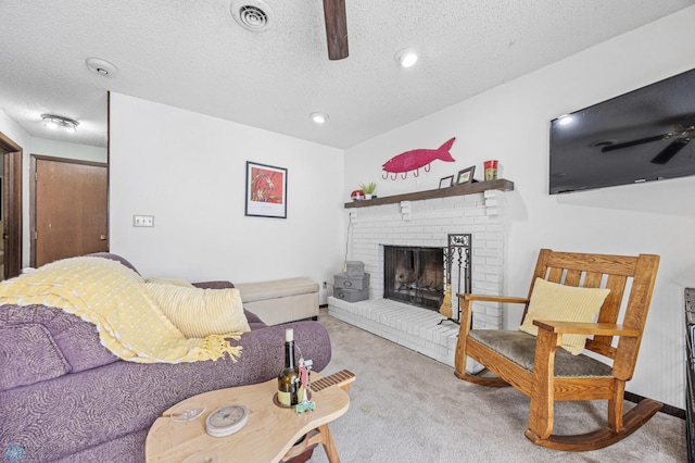 living room with light carpet, a textured ceiling, a fireplace, and ceiling fan