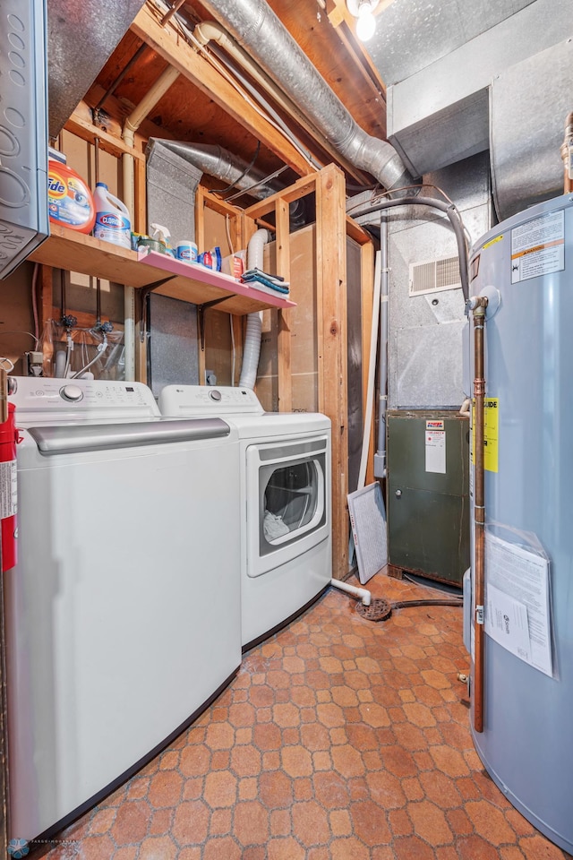 laundry room featuring water heater and washer and dryer