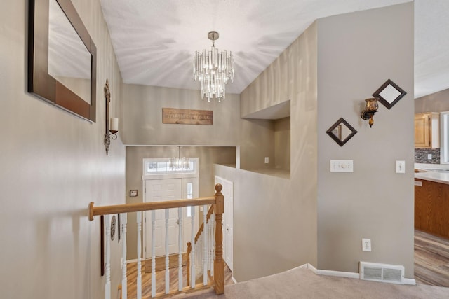 staircase featuring carpet and an inviting chandelier