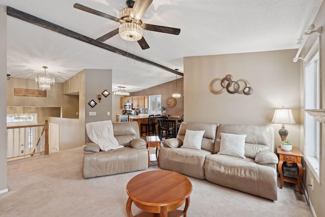 carpeted living room featuring vaulted ceiling with beams and ceiling fan with notable chandelier