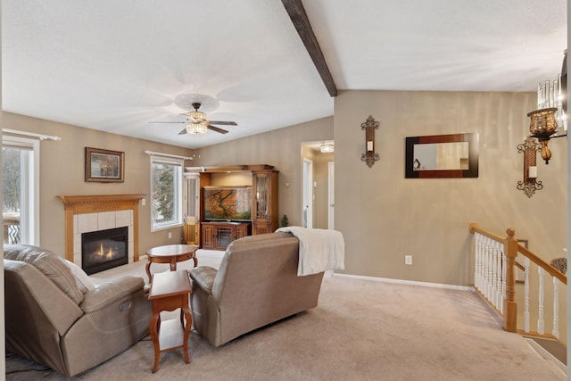 living room featuring a tiled fireplace, light colored carpet, ceiling fan, and lofted ceiling with beams