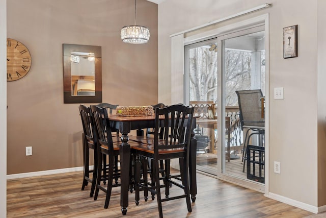 dining space with wood-type flooring and a chandelier