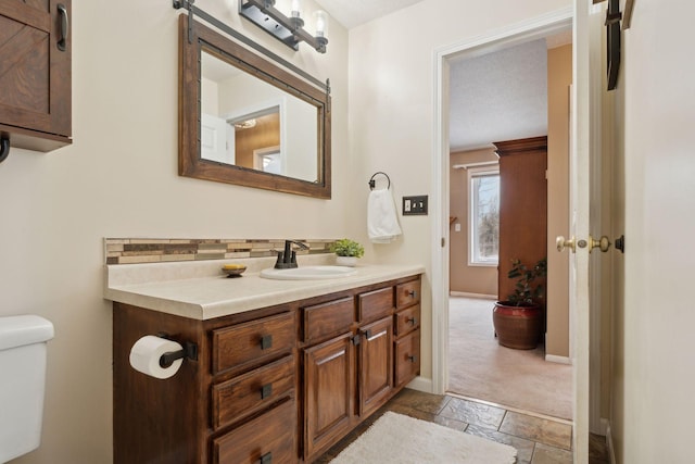 bathroom with vanity, a textured ceiling, and toilet