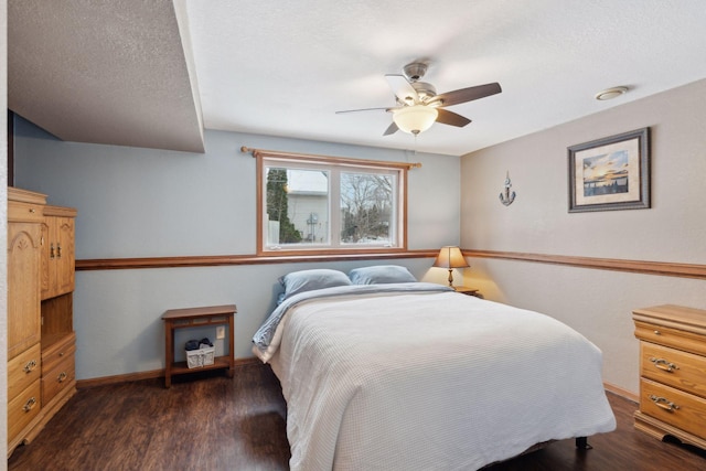 bedroom featuring ceiling fan, dark hardwood / wood-style floors, and a textured ceiling