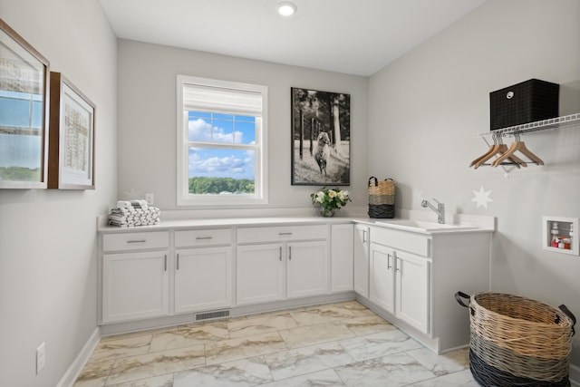 washroom with sink, hookup for a washing machine, and cabinets