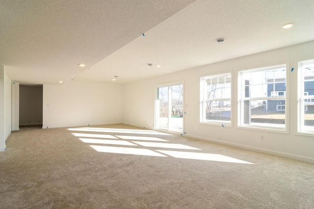 carpeted empty room featuring a textured ceiling