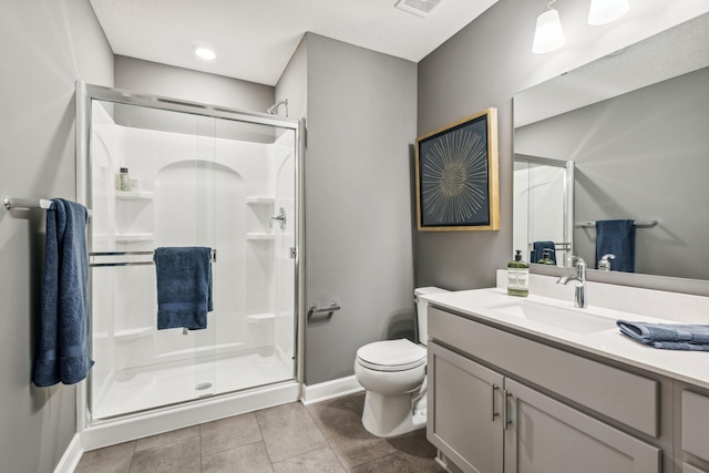 bathroom featuring a shower with door, vanity, tile patterned flooring, and toilet