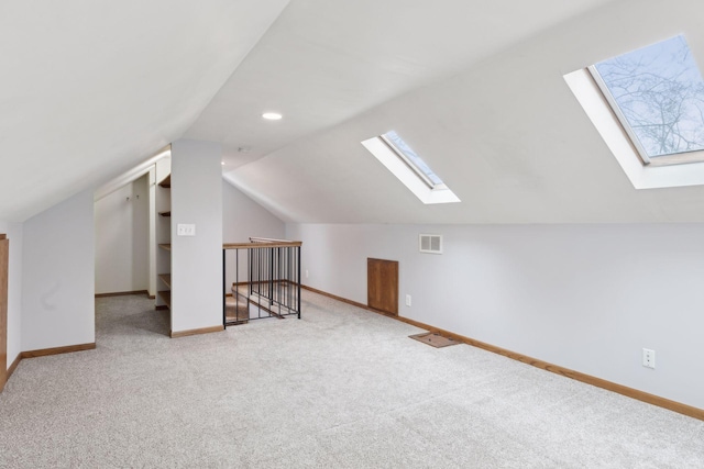 additional living space featuring vaulted ceiling with skylight and carpet floors