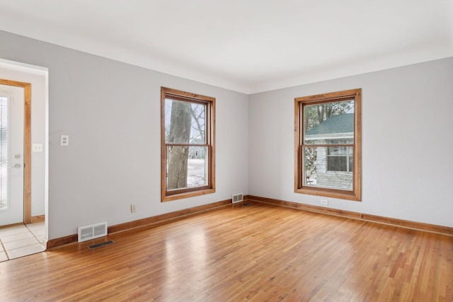 spare room featuring light hardwood / wood-style flooring and a wealth of natural light