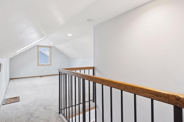 bonus room with vaulted ceiling and light carpet