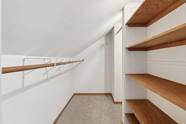 walk in closet featuring vaulted ceiling and light carpet