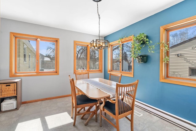 dining room with baseboards, a notable chandelier, and a healthy amount of sunlight