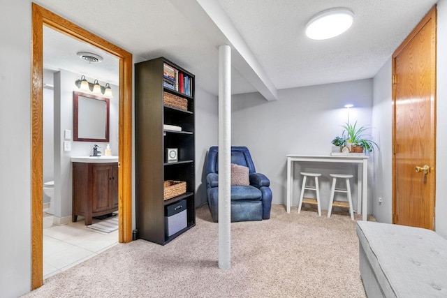 living area with light carpet, visible vents, and a textured ceiling